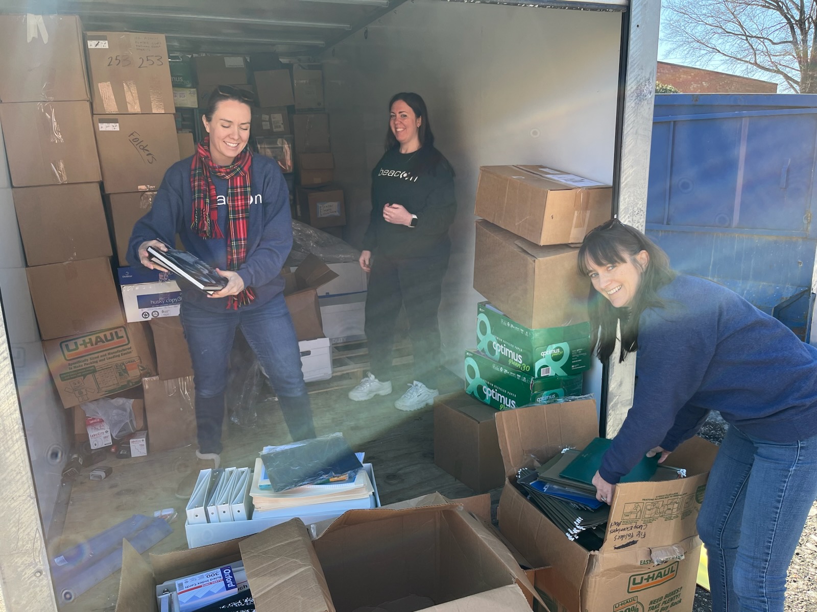 Beacon team members cleaning out a storage container at Guilford Education Alliance