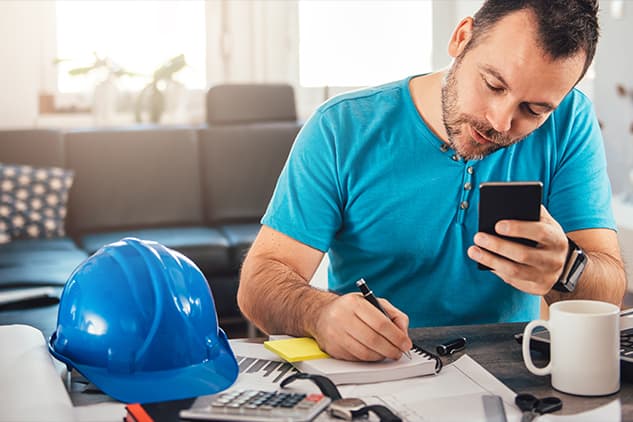 man with construction hat working on laptop