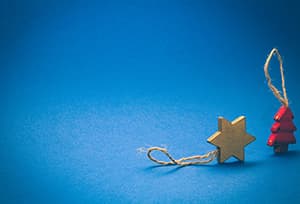 gold star of david ornament next to red christmas tree ornament 