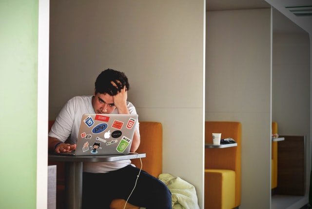student at a laptop, looking stressed