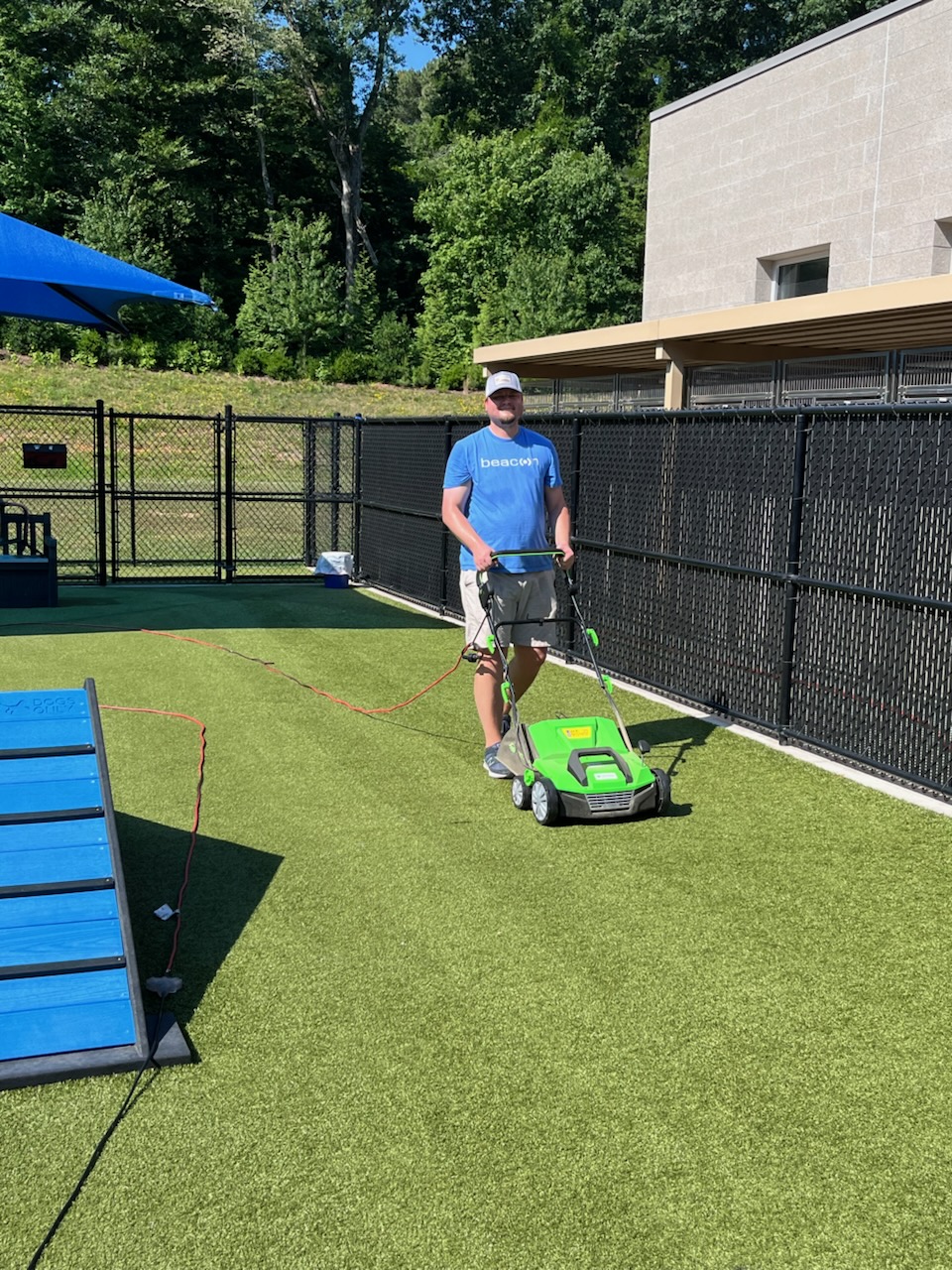 beacon team member cleaning a dog play yard at the animal shelter