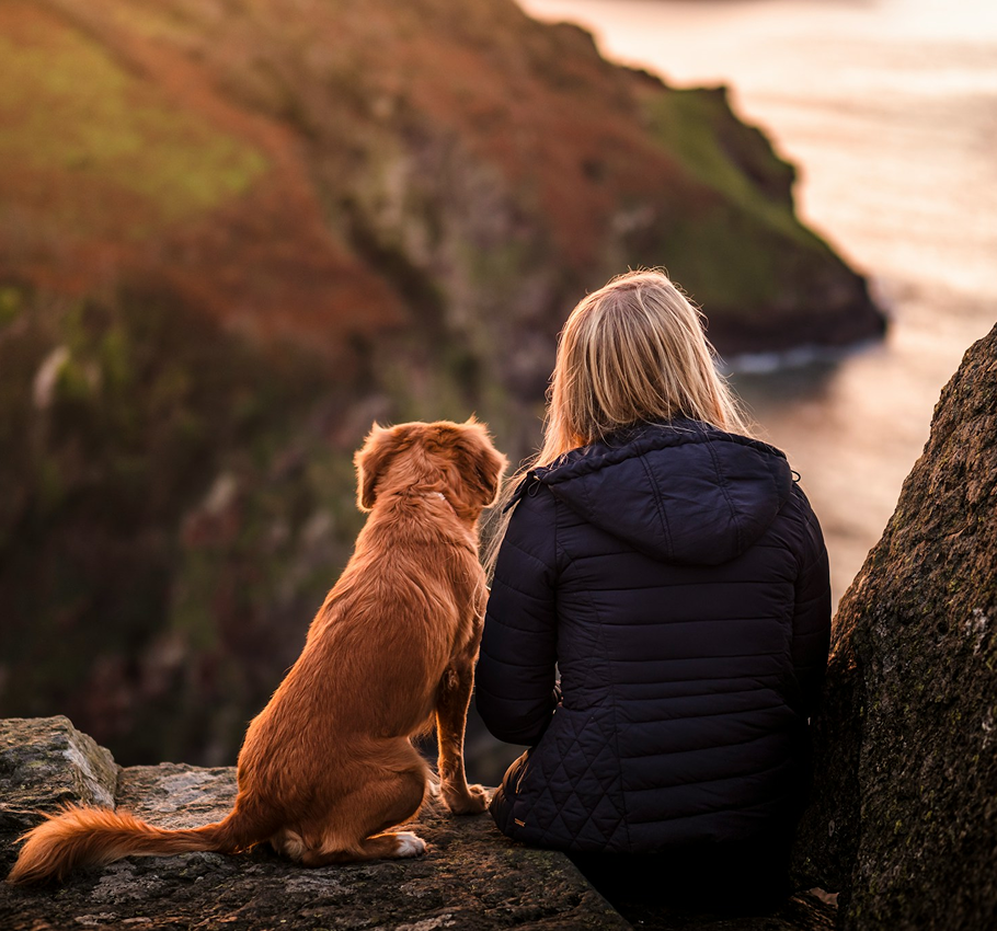 A woman enjoying a nice view with her dog