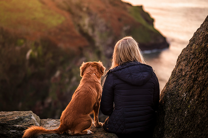 A woman enjoying a nice view with her dog