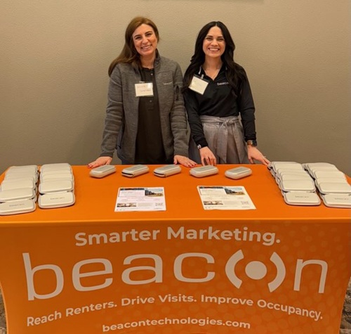 Two team members standing at a Beacon tradeshow booth.